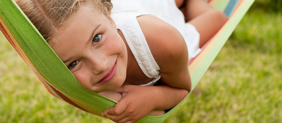 Bimba soddisfatta si riposa in un'amaca su un prato dell'Alto Adige