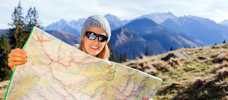 Woman is studying a route map in the mountains of South Tyrol