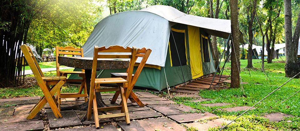 Tenda eretta nel verde con mobili da giardino