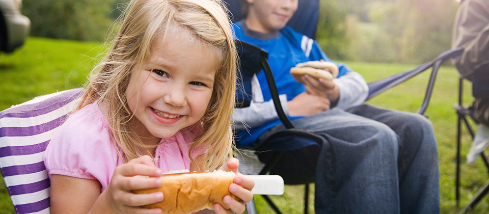 Piccola bimba felice con un panino per merenda