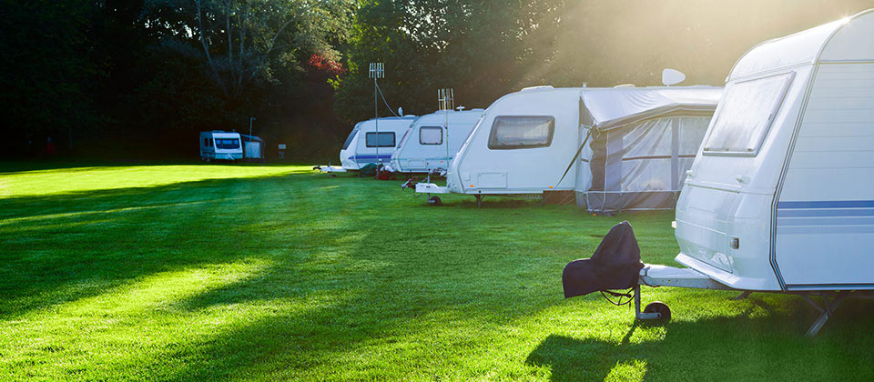 Alcuni camper parcheggiati su un prato verde di un camping dell'Alto Adige