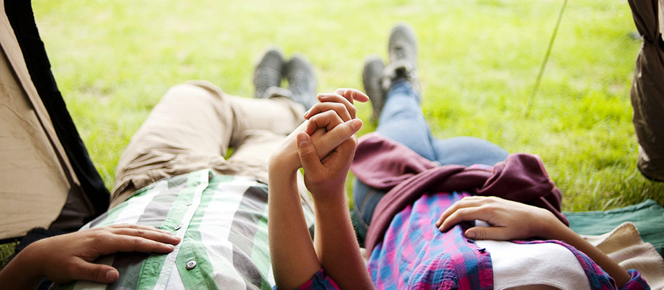 Coppia che si rilassa mano nella mano nella propria tenda