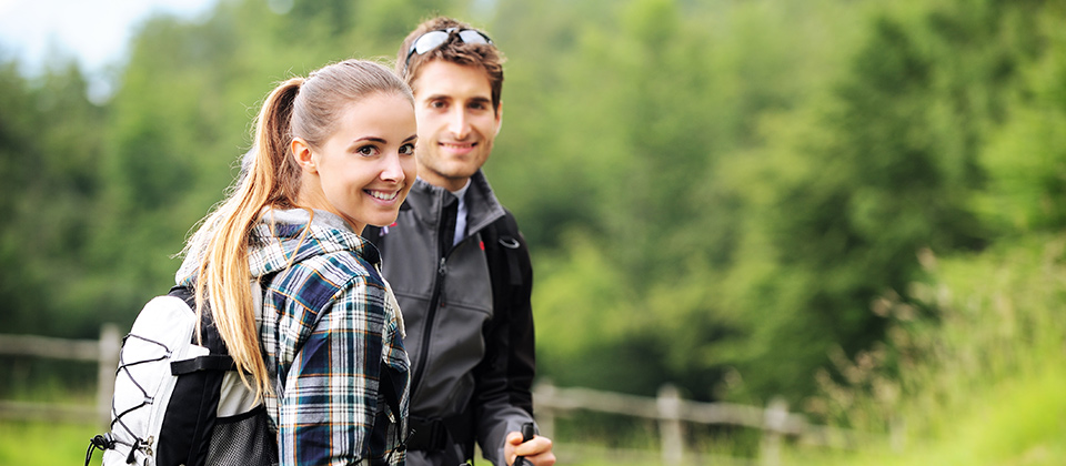 Coppia sorridente durante un escursione nei boschi dell'Alto Adige